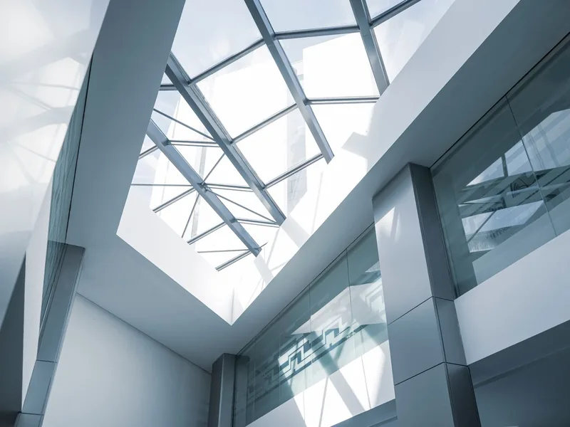 Modern commercial building interior with a glass ceiling and steel framing